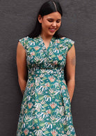 Close up of model wearing floral dress with dark green background 100 percent cotton retro style 