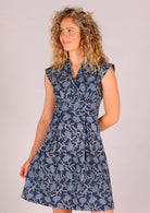 Model wearing cap sleeve Indian printed navy blue cotton floral dress with modest V-neckline 