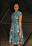 Woman wearing the 100% cotton Billie Dress Verdure, a structured cotton sundress with cap sleeves and a teal wildflower print.