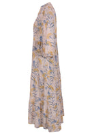 Side view of a full length maxi dress with 3 tiered flowy skirt, mandarin collar, buttoned bodice and pockets
