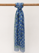 Blue patterned scarf tied around a wooden rod on a white background