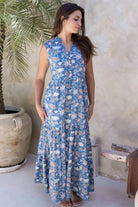 Model standing in a 100 percent cotton relaxed fit maxi dress with buttoned bodice, pockets and tiered skirt.