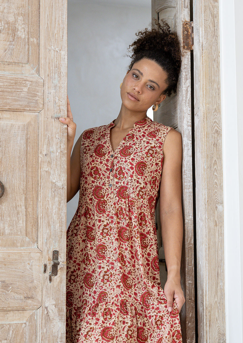 Woman wearing a 100% cotton dress standing in a doorway.
