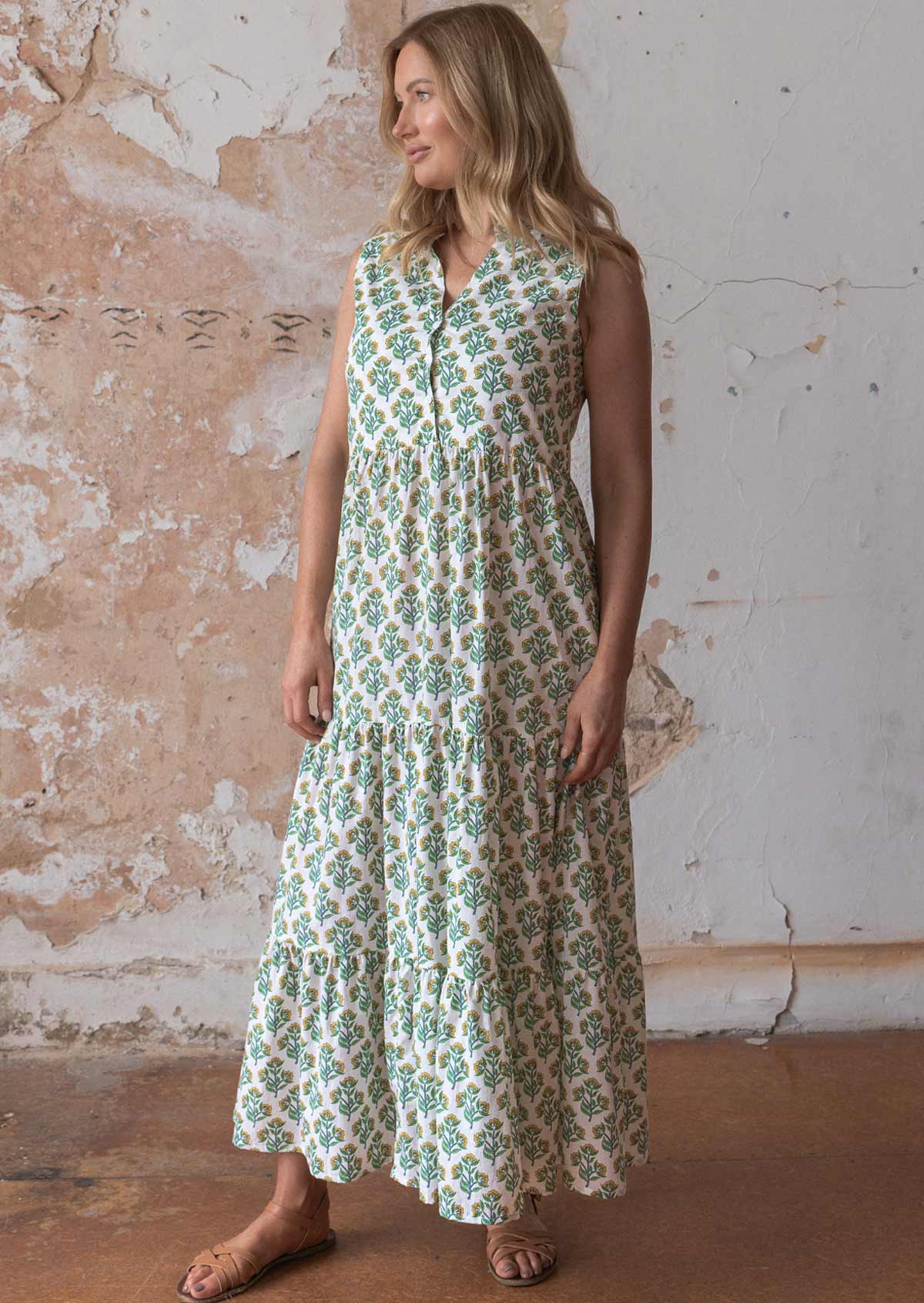 Model poses in cotton sleeveless maxi dress with yellow and green floral print on white base