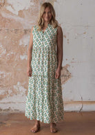 Woman stands in cotton sleeveless maxi dress with buttoned bodice, V-neckline and mandarin collar