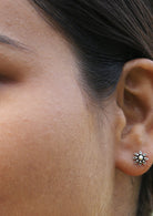 Woman wearing Silver Flower Studs with intricate floral design and secure butterfly backs