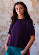 Woman wearing loose fit dark purple rayon t-shirt with corduroy pants