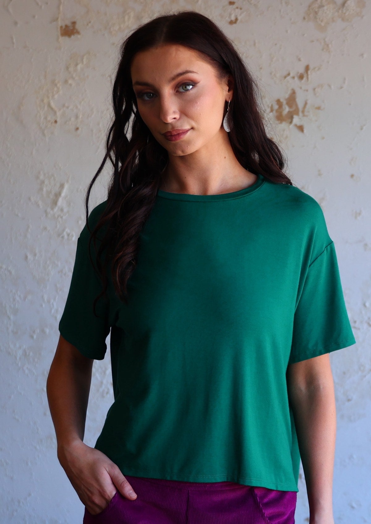 woman in jade green loose fit t-shirt with purple corduroy pants