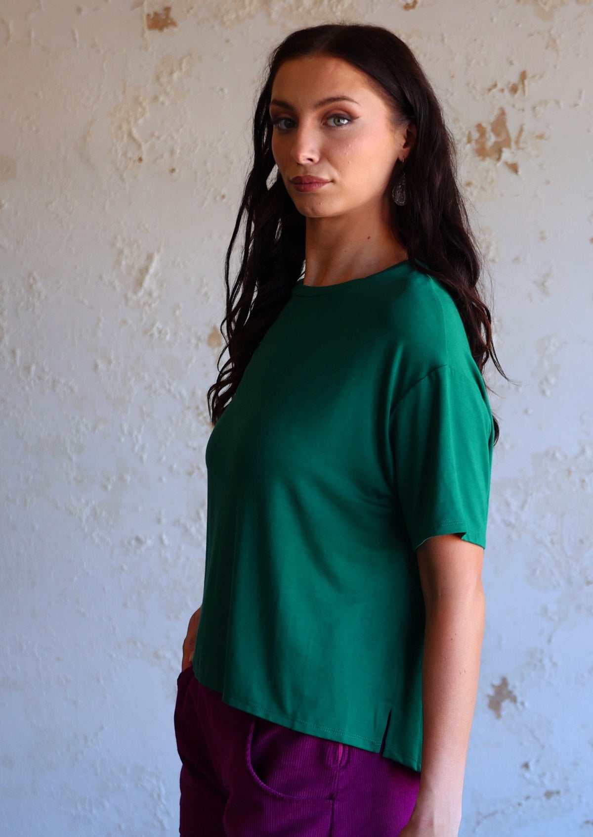 woman in jade green loose fit t-shirt over purple pants