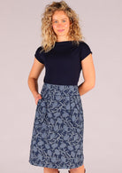 Model wearing Bridgette Skirt Neela navy cotton retro pencil skirt with one hand in pocket 