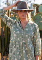 Close up of woman in cotton maxi dress with buttoned bodice that forms a V-neckline topped with a mandarin collar