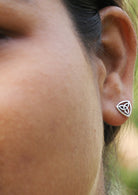 Close up of a woman wearing a Celtic triangle studs with intricate design.