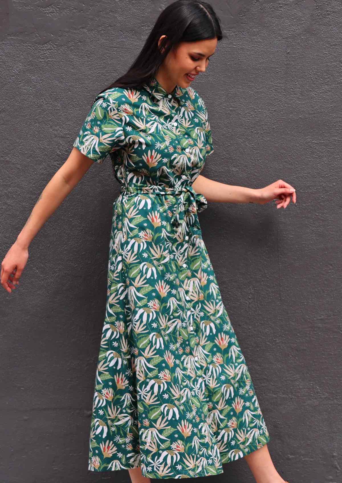 Woman with dark hair wearing 100% cotton green floral shirt dress, tie waist