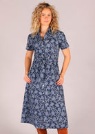 Model with hands in pockets wearing Chelsea Dress Neela 100 percent cotton shirt dress featuring pockets, waist tie, and collar