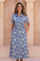 Woman wears 100% cotton button through shirt style dress with pockets, collar, short sleeves and a fabric waist tie.