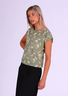 Model wears pale green cotton short sleeve top with rolled cuff