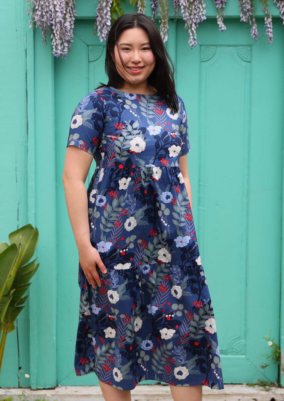 Woman with dark hair wearing a  blue floral cotton dress 