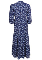Back view of a full length maxi dress with 3 tiered flowy skirt, mandarin collar, buttoned bodice and pockets