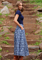 Model posing side on wearing Cora Skirt Neela navy button down 100 percent cotton maxi skirt with hand in pocket