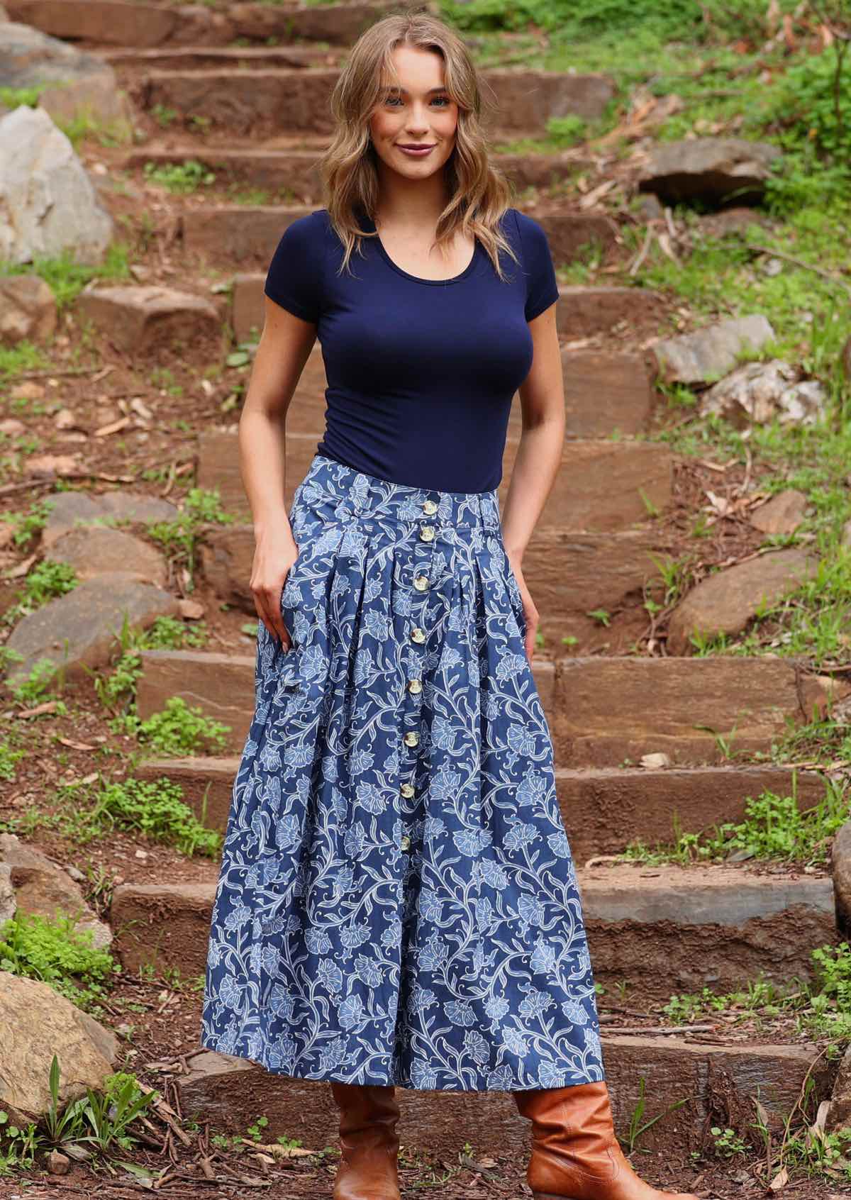 Model wearing Cora Skirt Neela navy button down cotton maxi skirt with thumbs in pockets