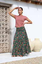 Model wears floral printed, cotton tiered maxi skirt with wide elasticated waistband. Paired with wide neck dusty rose top. 