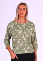 Woman wears relaxed fit cotton top with 3/4 sleeves and round neckline in green and cream floral print