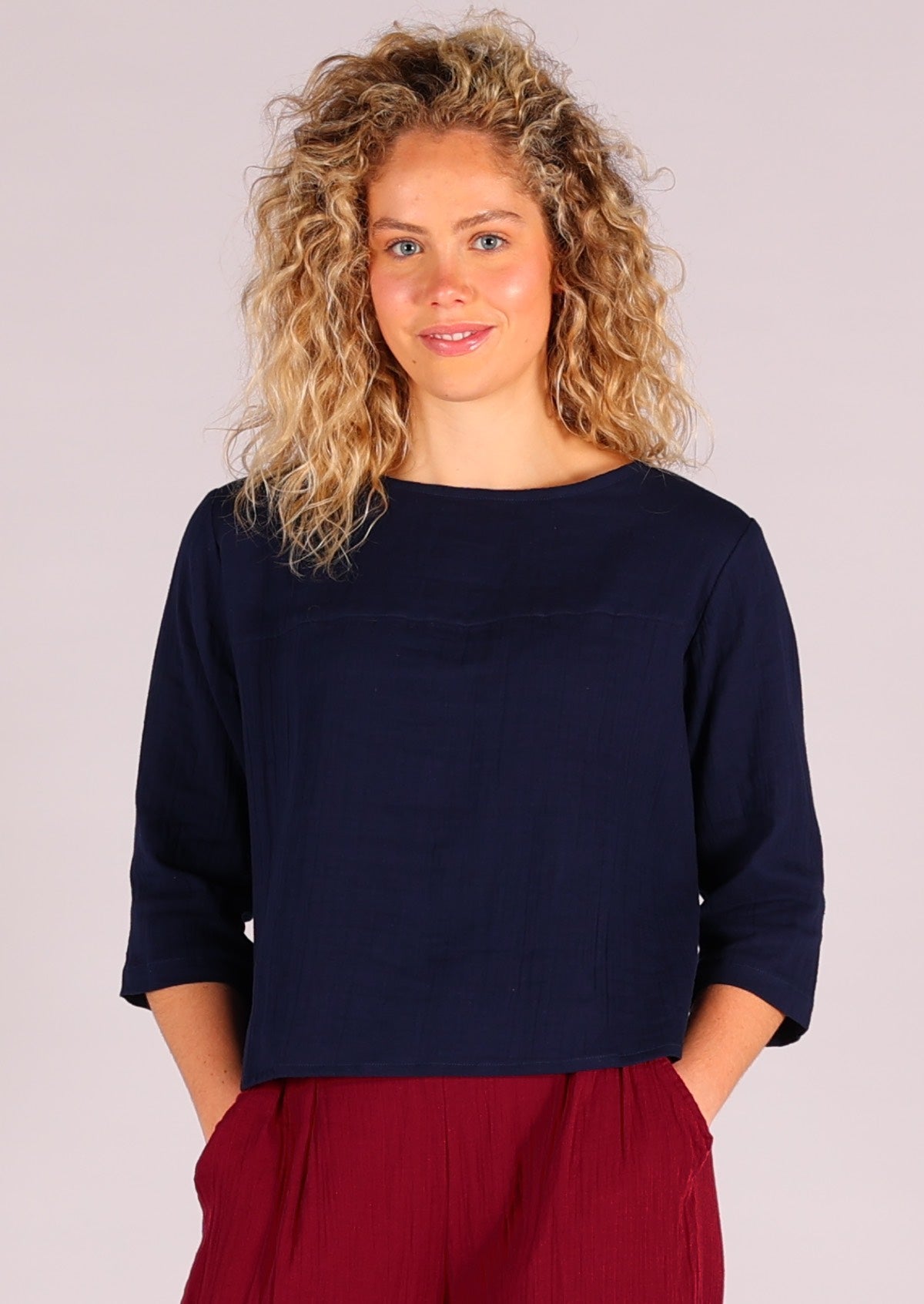 Model wears dark blue double cotton top with 3/4 sleeves and high round neckline
