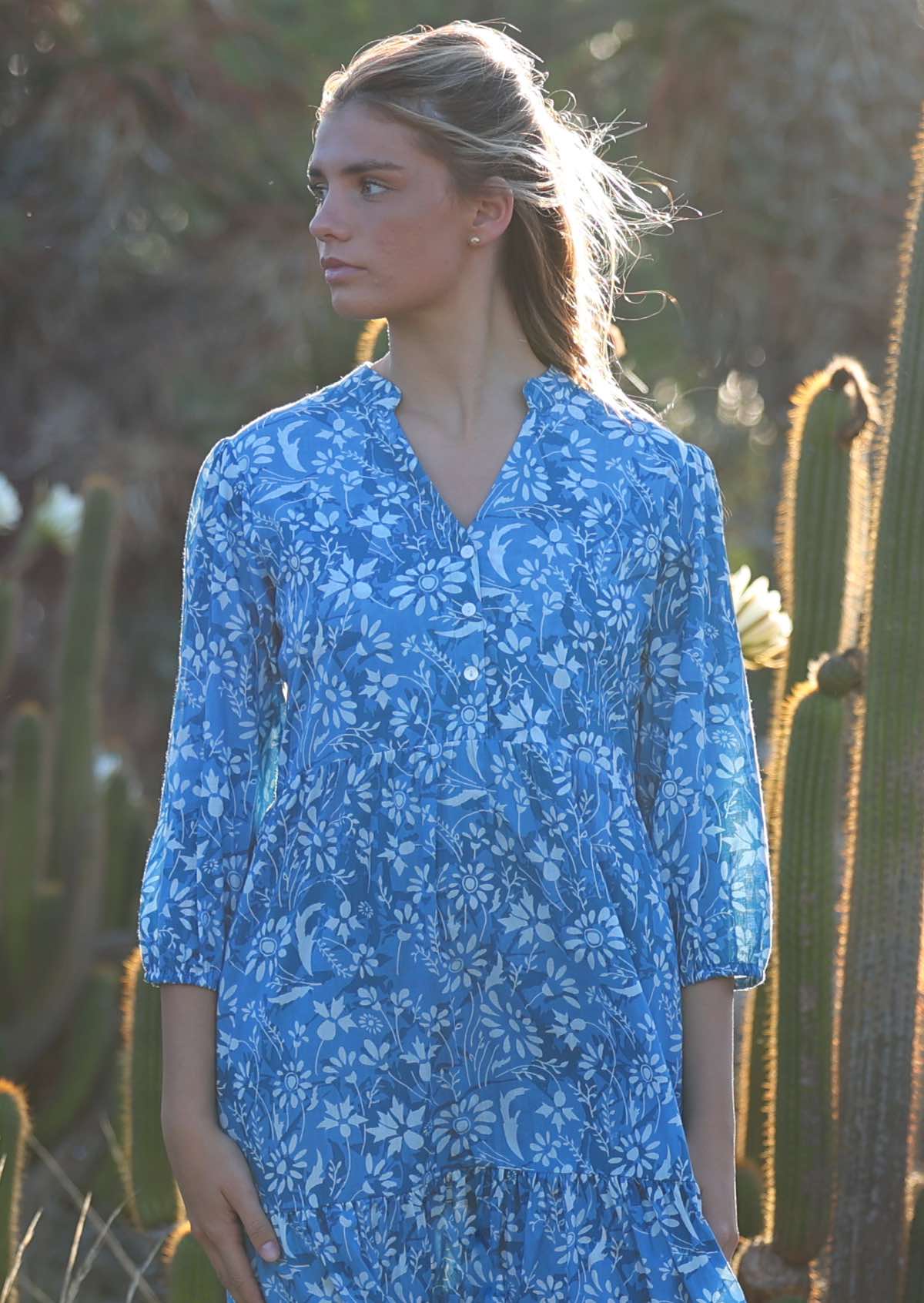 woman in blue cotton maxi dress with light blue and white floral print with sunlight in hair