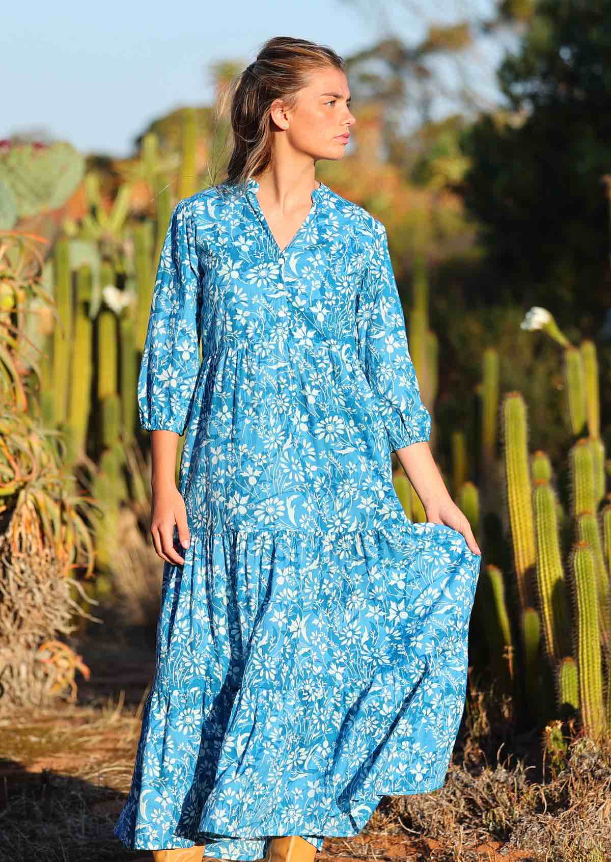 woman in blue cotton maxi dress with light blue and white floral print with full skirt