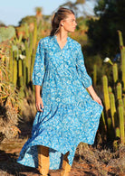 woman in blue cotton maxi dress with light blue and white floral print with full skirt held out