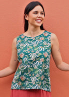 Model wears cotton sleeveless top with high round neckline in green based floral print