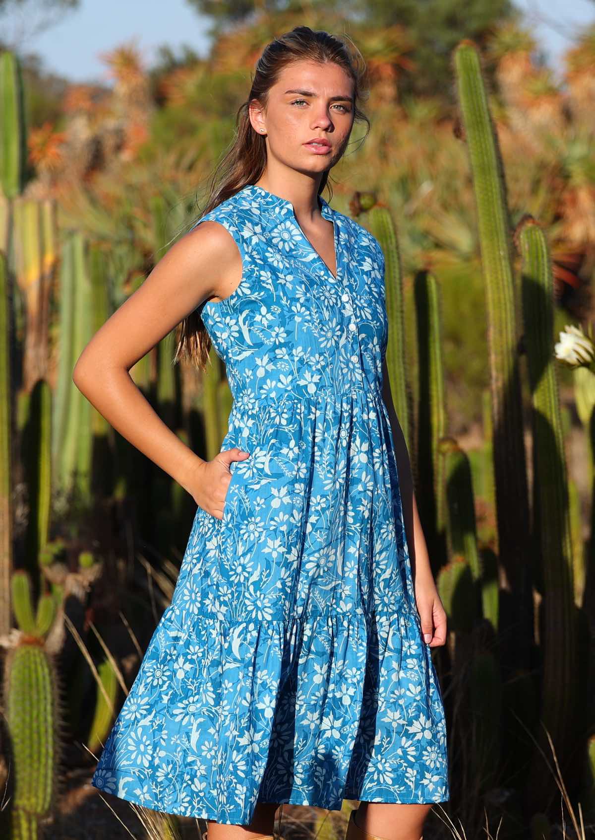 woman in blue floral cotton midi dress with hand in pocket