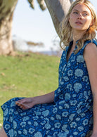 Close up of woman in cotton sleeveless relaxed fit blue floral dress with buttoned bodice and mandarin collar