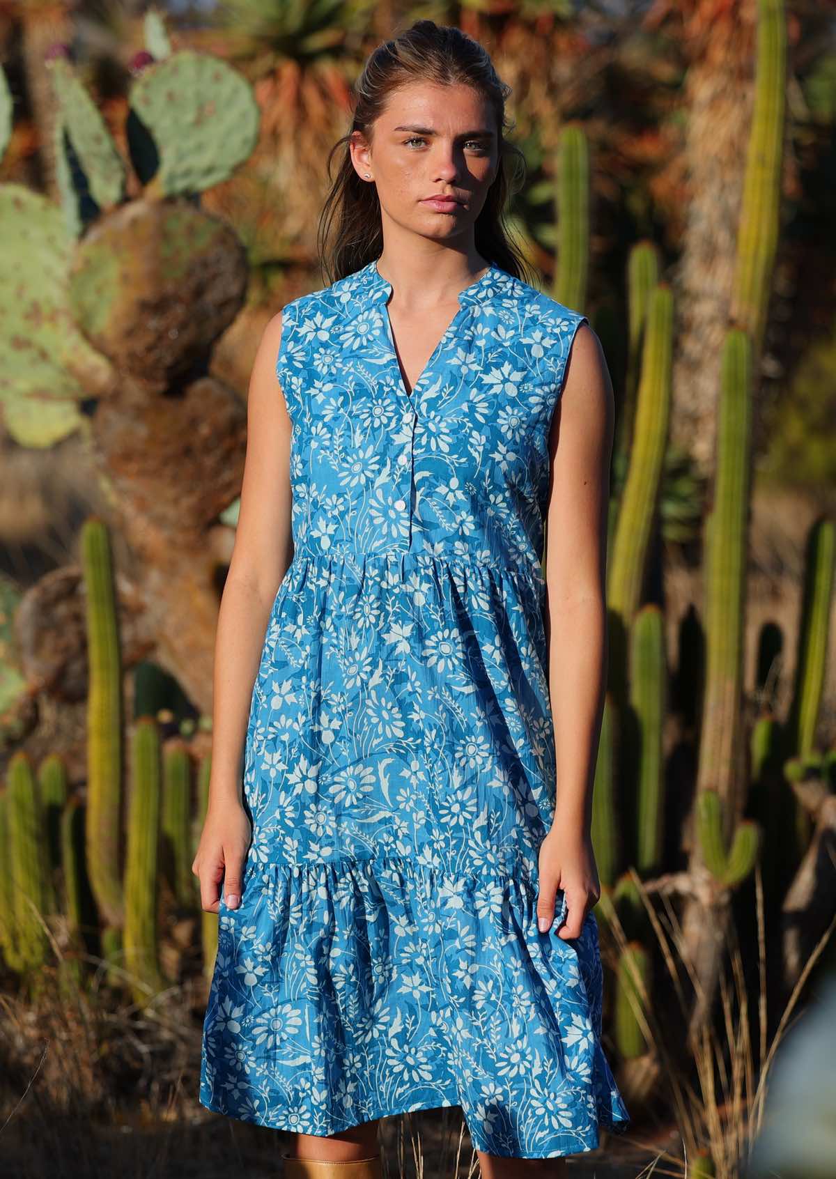 woman in blue floral cotton sundress in front of cacti 