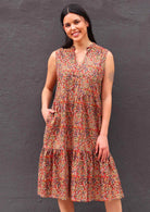 Model standing with one hand in pocket wearing Wild Spice print midi length sleeveless Indian cotton sundress