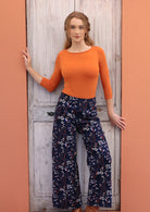 Model in 100% cotton corduroy floral printed wide leg pants paired with long sleeve boat neck top orange.