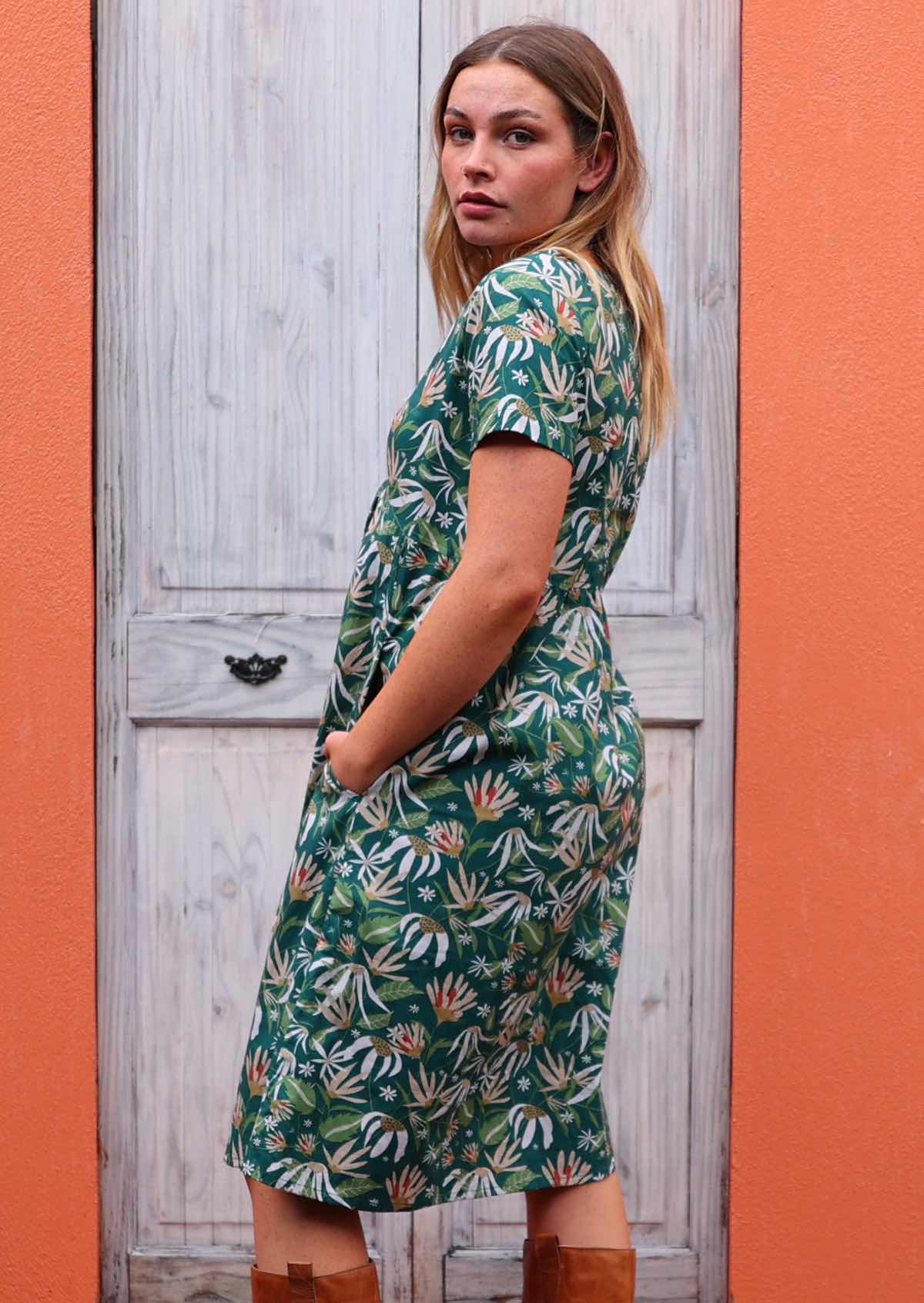 Model wearing Etta Dress Flannel Flower cotton green sundress with short sleeves back view 