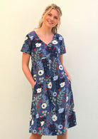 Model wears 100% cotton relaxed fit knee length dress with short sleeves and an empire waistline in bold blue floral print