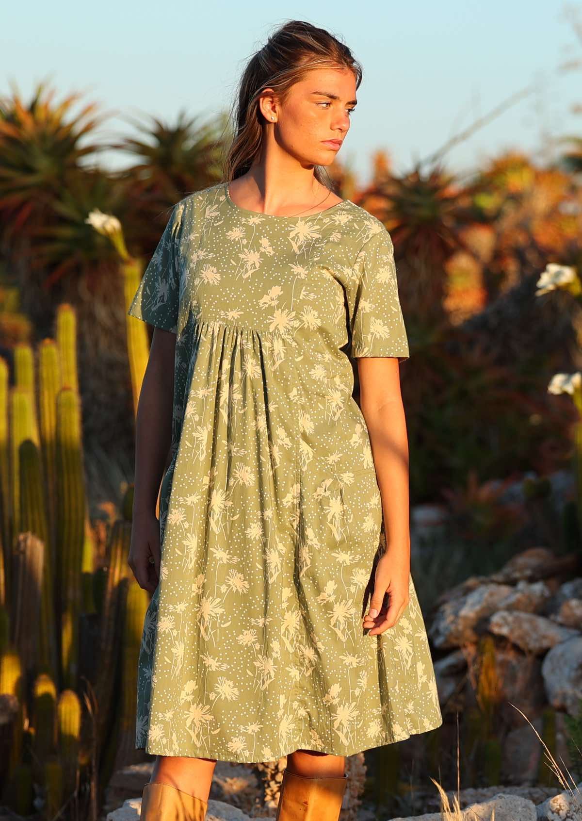 Setting-sun drenched photo of model in cotton sun dress with gathers under the bust and pockets