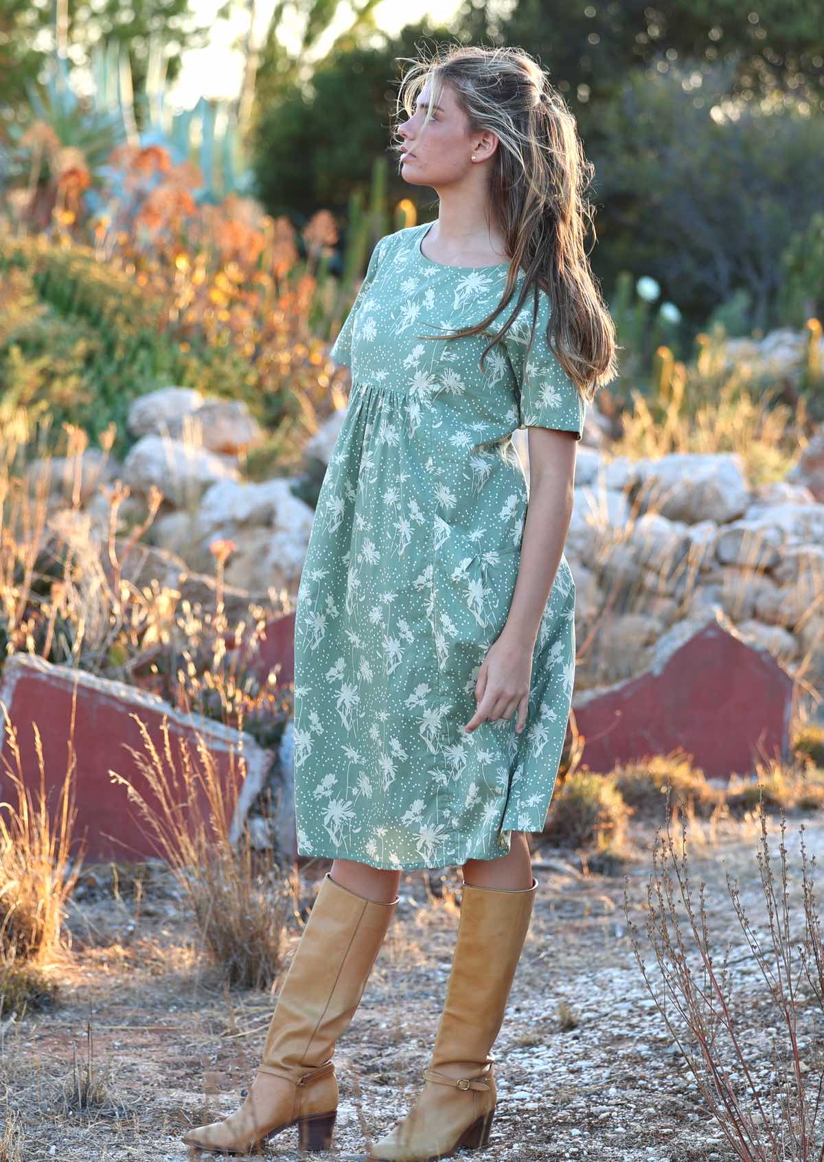 Model stands sideways in loose fit cotton dress with gathers under the bust and T-shirt style sleeves