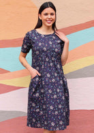 Woman in Indian print cotton dress with pockets in front of sun mural