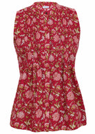 The front view of red sleeveless blouse has a floral print of pink and white flowers, green stems, a button-up collar, and vertical pleats