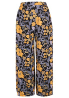 Floral-patterned cotton pants with yellow and blue-grey flowers on a black base, with pockets