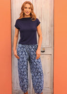 Model standing wearing Greta Pant Neela navy 100 percent cotton relaxed fit pants with her thumbs in pockets