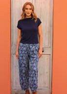 Model standing wearing Greta Pant Neela navy 100 percent cotton relaxed fit pants paired with navy top 