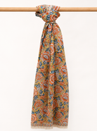 Colorful patterned cotton scarf on a wooden stick against a white background