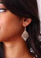 Close-up of a woman wearing a Large Hill Tribe silver earring with a textured design.
