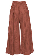 Back view of 100% cotton wide leg pants in rust shade with elastic waist and pockets