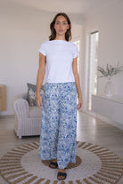Woman in a white based blue floral cotton pant with plain white basic top