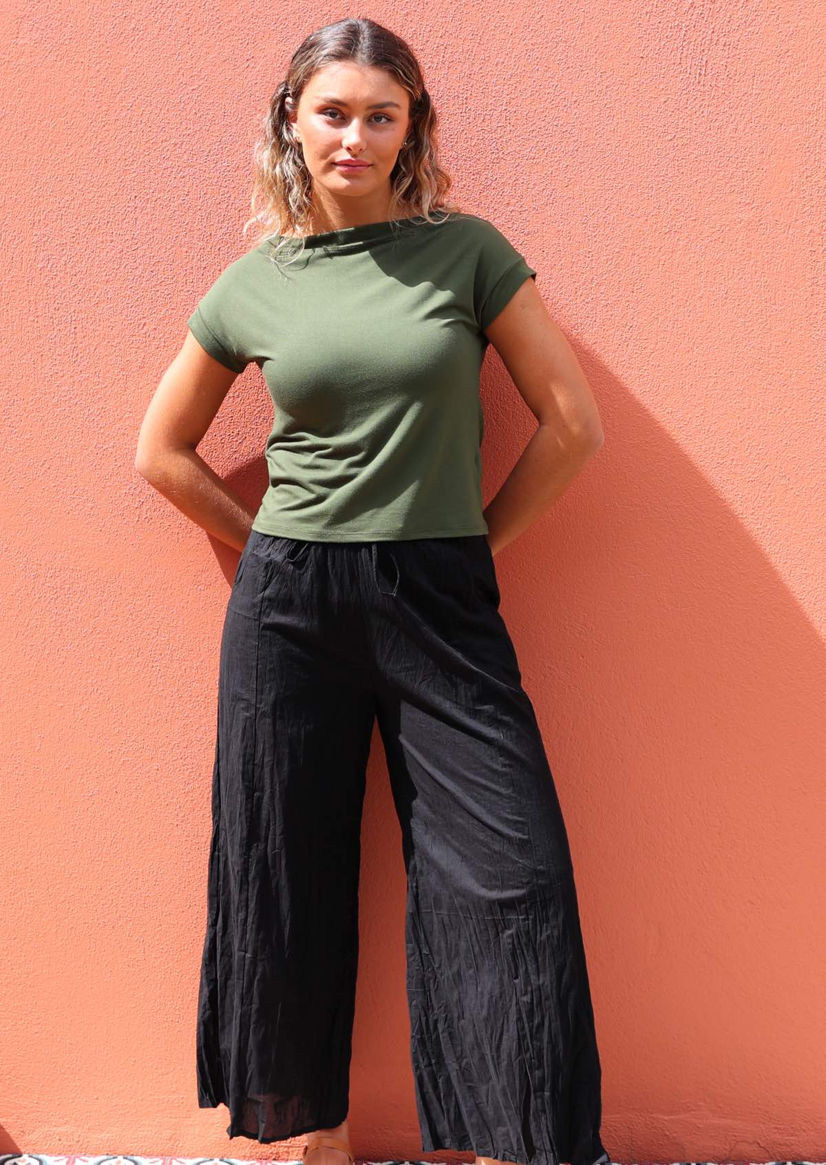 Woman wearing black cotton wide legged pants with green t-shirt